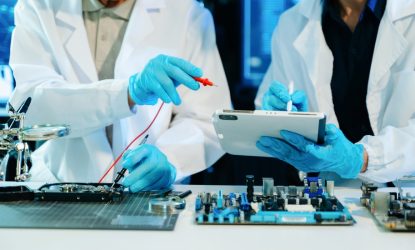 Engineers repairing computer hardware and analyzing data storage systems in a high-tech lab with cybersecurity monitoring, diagnostics, and digital technology innovation.