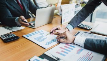Group of business people meeting analyzing financial documents at meeting